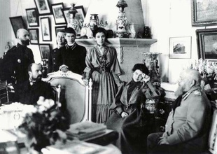 В доме Олсуфьевых на Фонтанке, Петербург. Сидят (слева направо): Ю. А. Олсуфьев, Л. В. Глебова и А. В. Олсуфьев. Стоят (слева направо): П. И. Нерадовский, Владимир и Василий Комаровские, С. В. Олсуфьева. Около 1904.